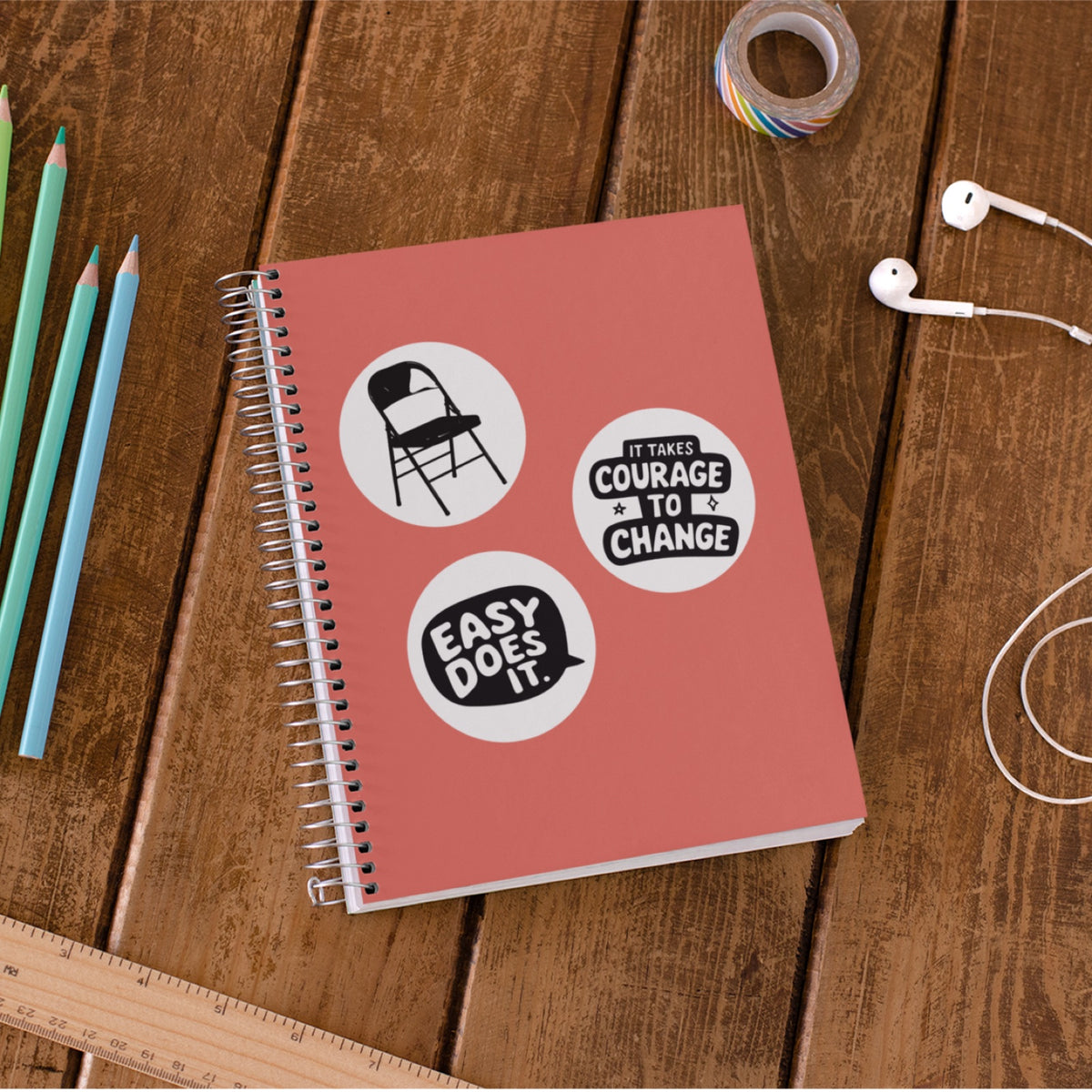 Folding chair, Easy Does It, and Courage to Change stickers on a coral notebook
